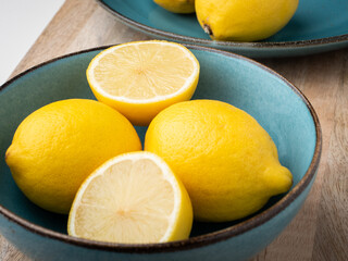 Half cut and whole lemons in a bowl. Close-up, concept, nobody. 
