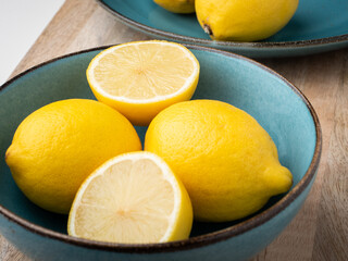 Half cut and whole lemons in a bowl. Close-up, concept, nobody. 
