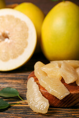 Slices of tasty pomelo fruit on table, closeup