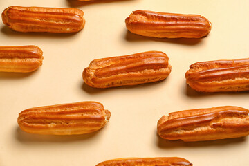 Tasty sweet eclairs on color background