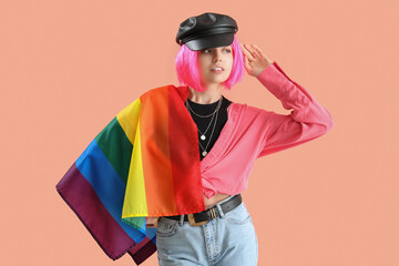 Young woman with LGBT flag on pink background