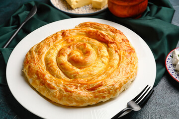 Plate with delicious cheese pie on black table