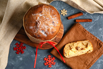 Tasty Panettone with snowflakes on dark table, top view