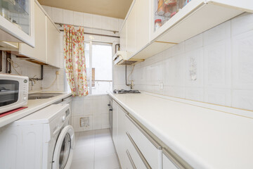 Old conventional kitchen with white cabinets, matching appliances and window with ugly flower curtains