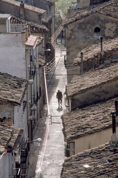 A lone figure walks the narrow streets of Olite, Spain.