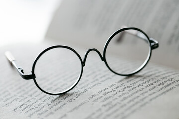 Reading glasses close-up on the pages of a book .Education and schooling concept.Symbol of study, knowledge and reading.