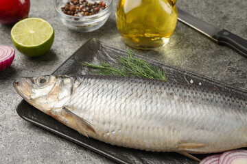 Delicious salted herring and ingredients on grey table, closeup