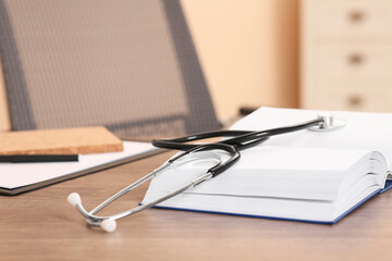 Book and stethoscope on wooden table indoors, space for text. Doctor education