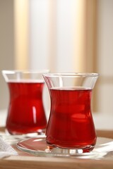 Glasses of traditional Turkish tea on wooden tray indoors