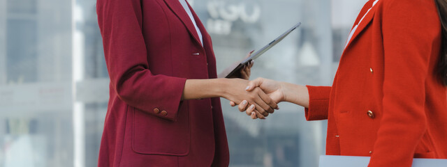Shaking hands, Two asia business women in conversation walking together on city street. Corporate colleagues workmate discussing new project while going to work. business outdoor. © NanSan