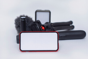Set of blogging gadgets. Smartphone mockup with a white screen with a tripod power bank with an action camera and a stabilizer with a microphone on a white background.