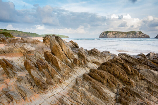 Mar e geologia, com pedras pontudas, rochas e ilhas.