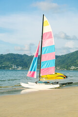 catamaran with colorful sail and speed boat on tropical beach. water sport summer vacation in Southeast Asia Thailand.