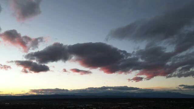 Drone Timelapse at sunset of Santa Fe, NM. Clouds rolling when airplanes.