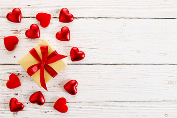 Valentine’s day. Present and red hearts on wooden background.