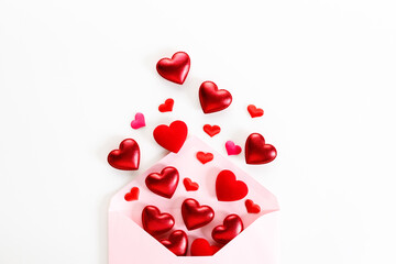 Envelope and red hearts on white background.