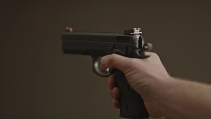 Thumb flipping down safety catch of 9mm pistol and dry firing