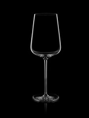 Empty transparent elegant glass for red wine from thin expensive glass on a black background. Silhouette. Glare. Outline. Studio shot.