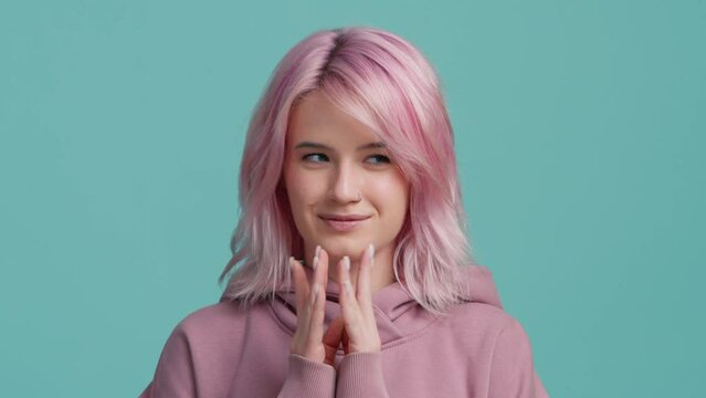 Cunning young woman pink hairstyle in hoodie thinking devious tricks cheating 4K