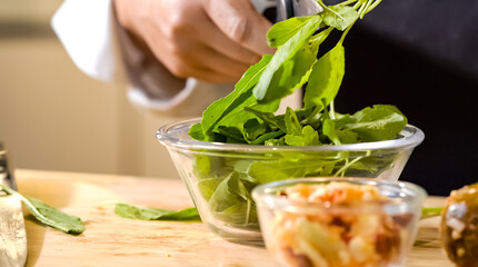 With the action of scissors snipping through crisp green vegetables, the chef expertly prepped a...