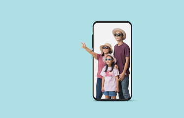 Happy asian family vacation, Father, mother holiday travel concept, with hand pointing in big smart phone frame, isolated on pastel plain light blue background