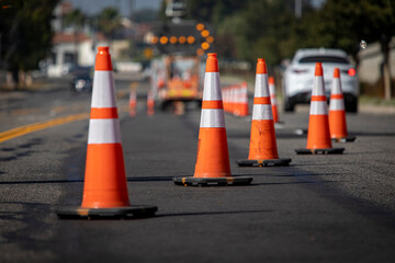 Traffic cones on road with electronic arrow pointing to the right to divert traffic and white car...