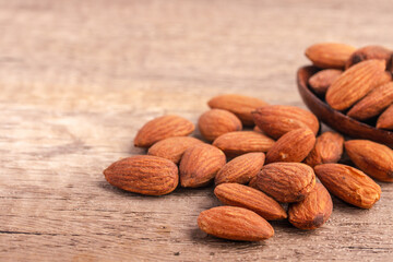 Salted almonds in wooden spoon on wooden background