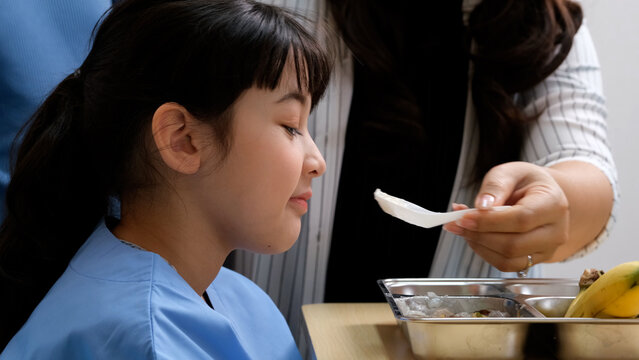 Sick girl patient lying in hospital bed feeling sad and losing appetite.