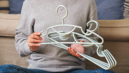 Closeup image of a woman holding plastic clothes hanger