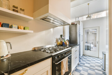 a kitchen with black and white checkered tiles on the floor, along with open shelvings for storage