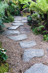 Stone slate pavement on small gravel in nature garden background