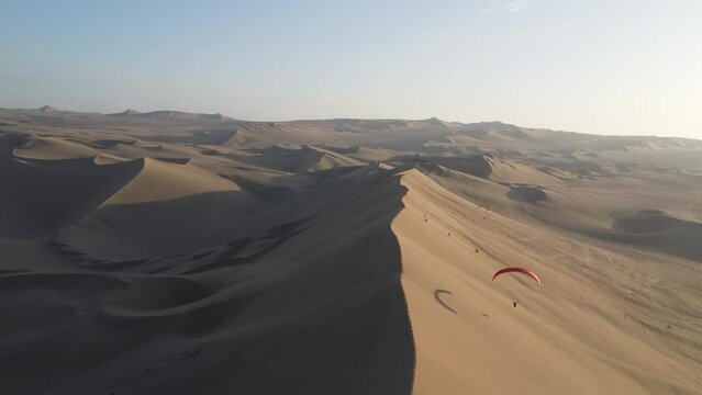 Paraglider flying in the desert. Huacachina, Peru