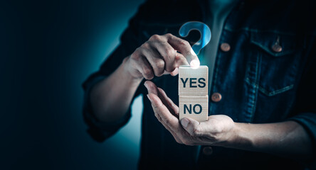 Businessman holding wooden block with YES or NO text for solution