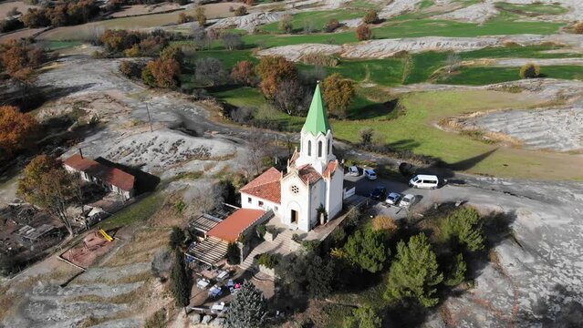Aerial: flying over a chappel in the catalan countryside in Spain. Circular shot