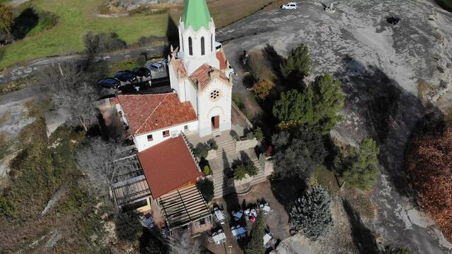Aerial: flying over a chappel in the catalan countryside in Spain. Pan shot