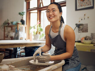 Clay, pottery or creative woman in workshop working on an artistic cup or mug in small business. Smile, artistic girl or happy Japanese designer manufacturing handicraft products as entrepreneur