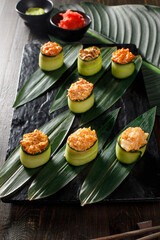 Assortment of different sushi rolls served on black plate