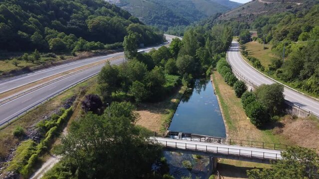 Aerial view of a River wedged between highways in a mountainous area