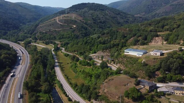 Aerial view of highways and a river surrounded by mountains
