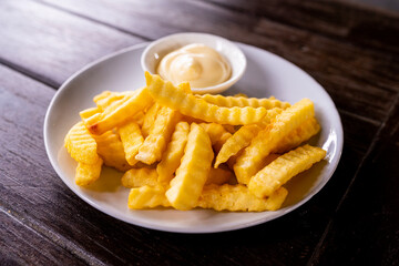 potato fries, golden brown and crispy, with a sprinkle of salt on top. The fries are arranged on a white plate or tray, and may be accompanied by dipping sauces or ketchup. 