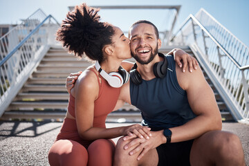 Sports, love and woman kissing man on stairs in city on break from exercise workout. Motivation, health and fitness goals, couple rest and kiss with smile on morning training run together in New York