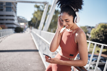 Music headphones, fitness and black woman with phone for social media in city. Exercise, sports and female athlete streaming radio or podcast on 5g mobile smartphone after training outdoors on street