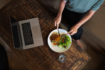 Сlose-up hands holding a plate of food, top view.