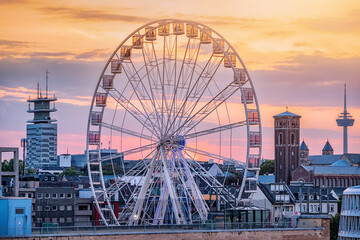 Ferris wheel in Cologne, Germany with a view of the architectural sights of the city at sunset