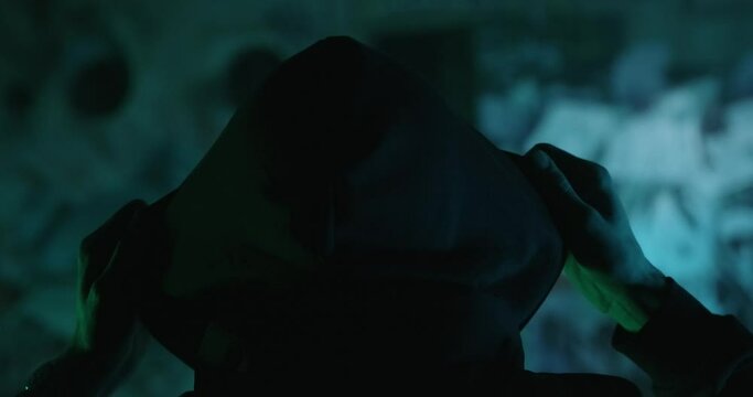 A man puts on a hoodie.