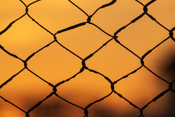 sky at sunset through iron wire
