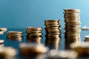 Building up wealth. Stacked coin and bokeh on blue background.