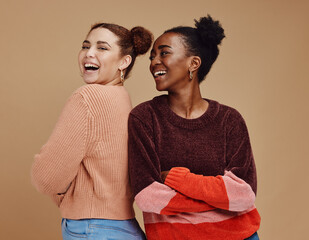 Fototapeta Happy, smile and women friends in a studio together with fun, freedom and positive mindset. Happiness, excited and interracial girl best friends smiling with style while isolated by brown background. obraz