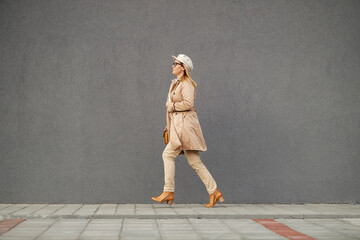 A busy stylish woman is running and rushing on the street downtown.