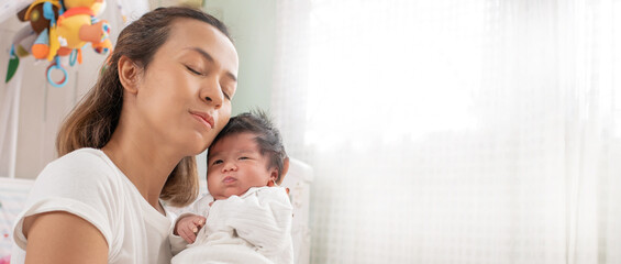 happy loving family. mother playing with her baby hugging in the bedroom , portrait of asian mother playing with newborn baby, health care family love together. asian girl lifestyle..